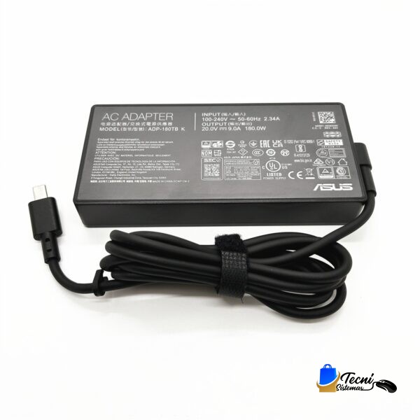 ASUS AC adapter with a coiled power cord and plug, lying on a white surface; label shows input 100-240V and output 20V for laptops.