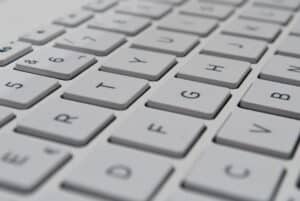 Teclado blanco con prompt de inteligencia artificial y productividad digital
