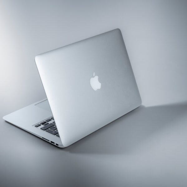 MacBook plateada en mesa blanca con precios de Apple 2026