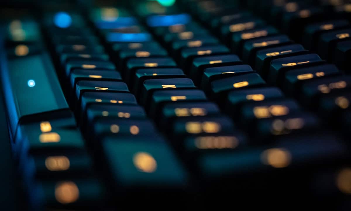 Teclado negro con código y prompt engineering en pantalla