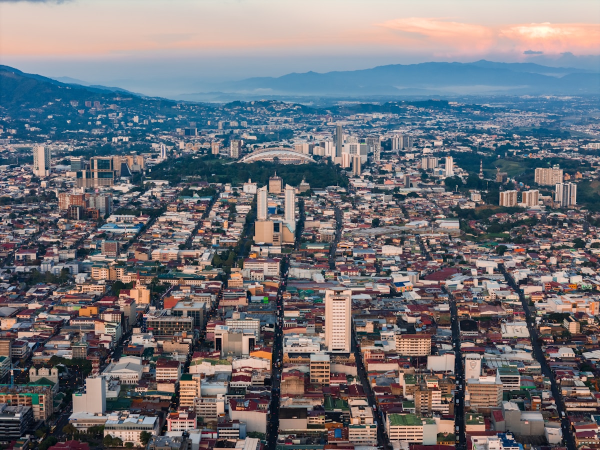 Vista aérea de ciudad con montañas al fondo representando Costa Rica digital